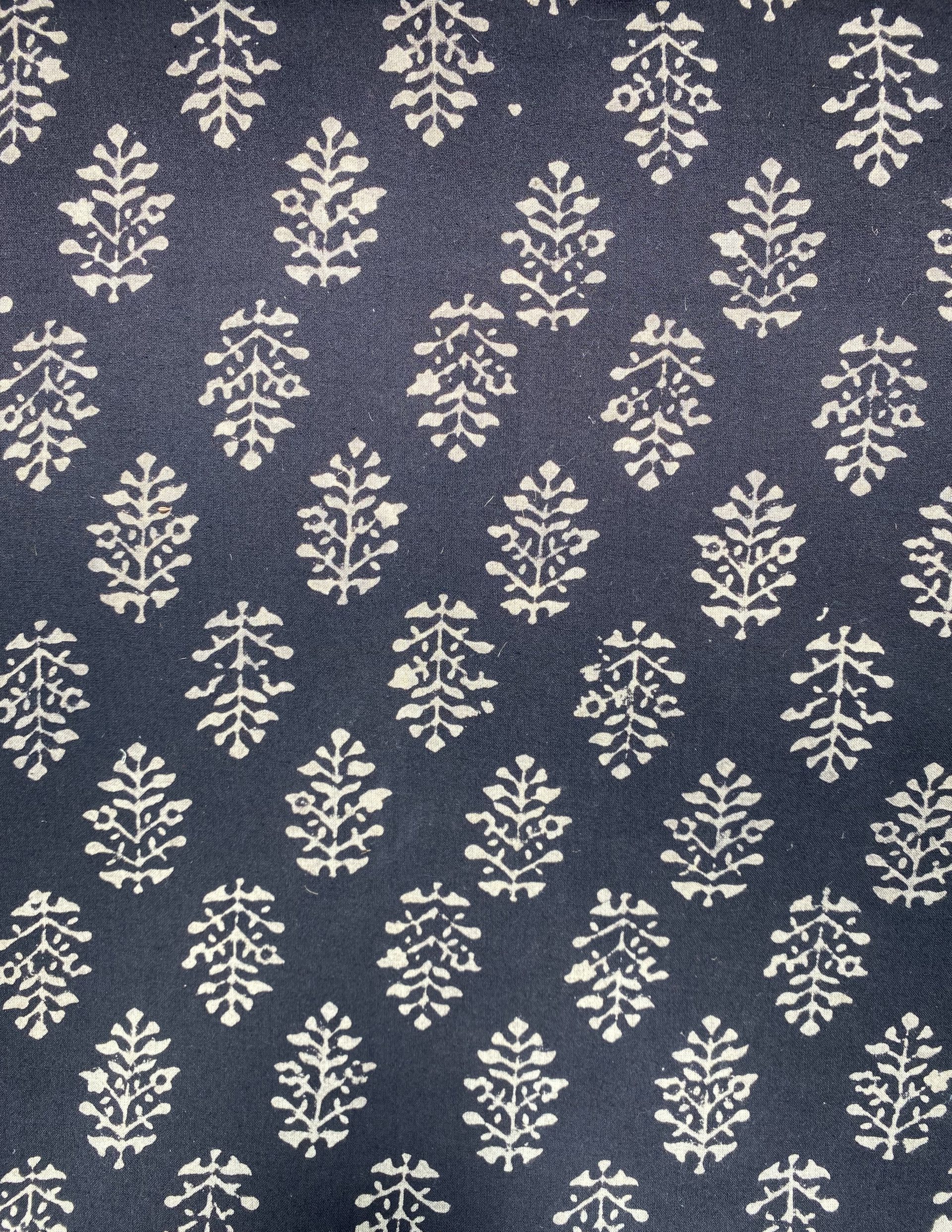 Black fabric featuring repeating white botanical motifs arranged in vertical clusters as a decorative pattern.