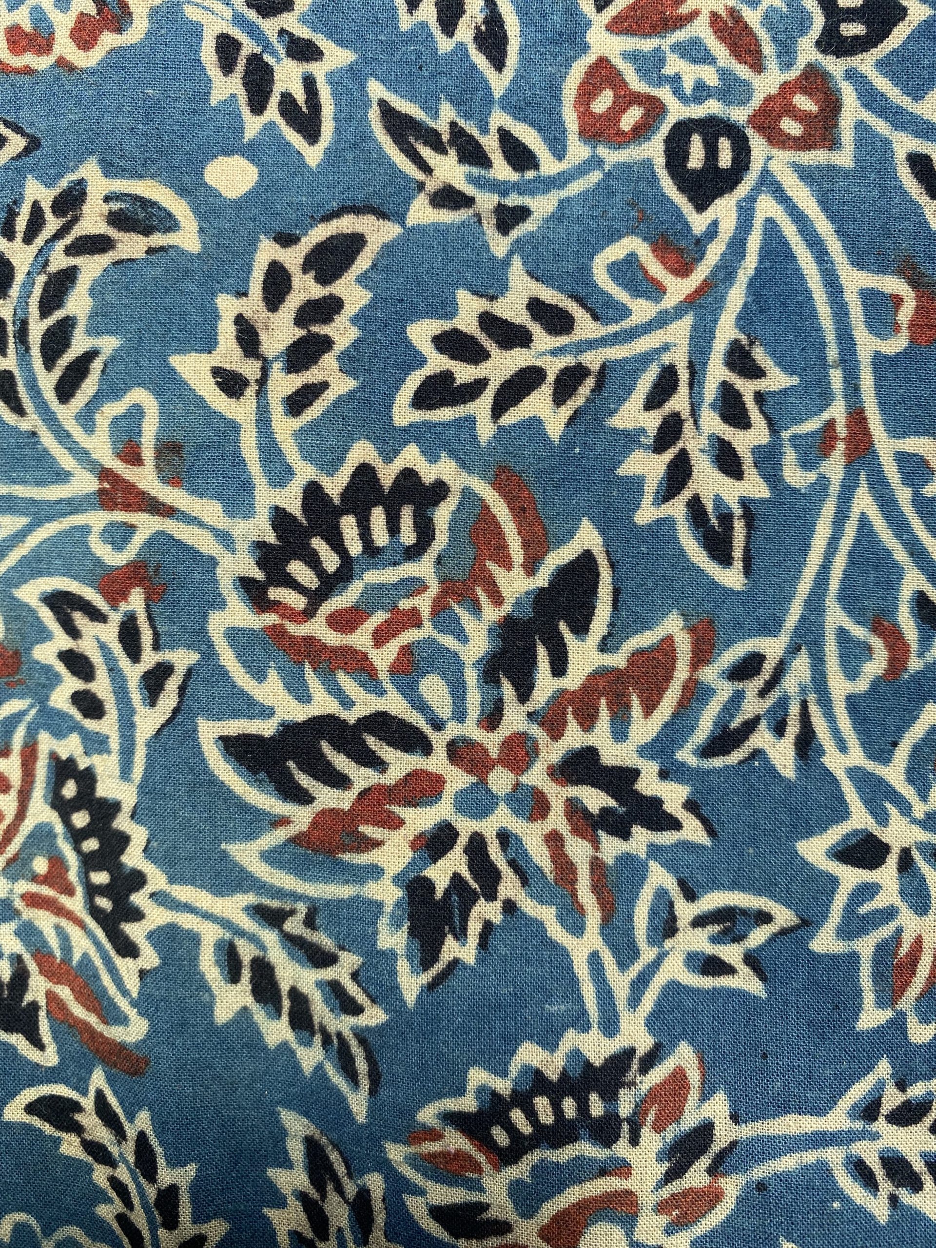 Blue fabric with cream and navy floral pattern and red accents.