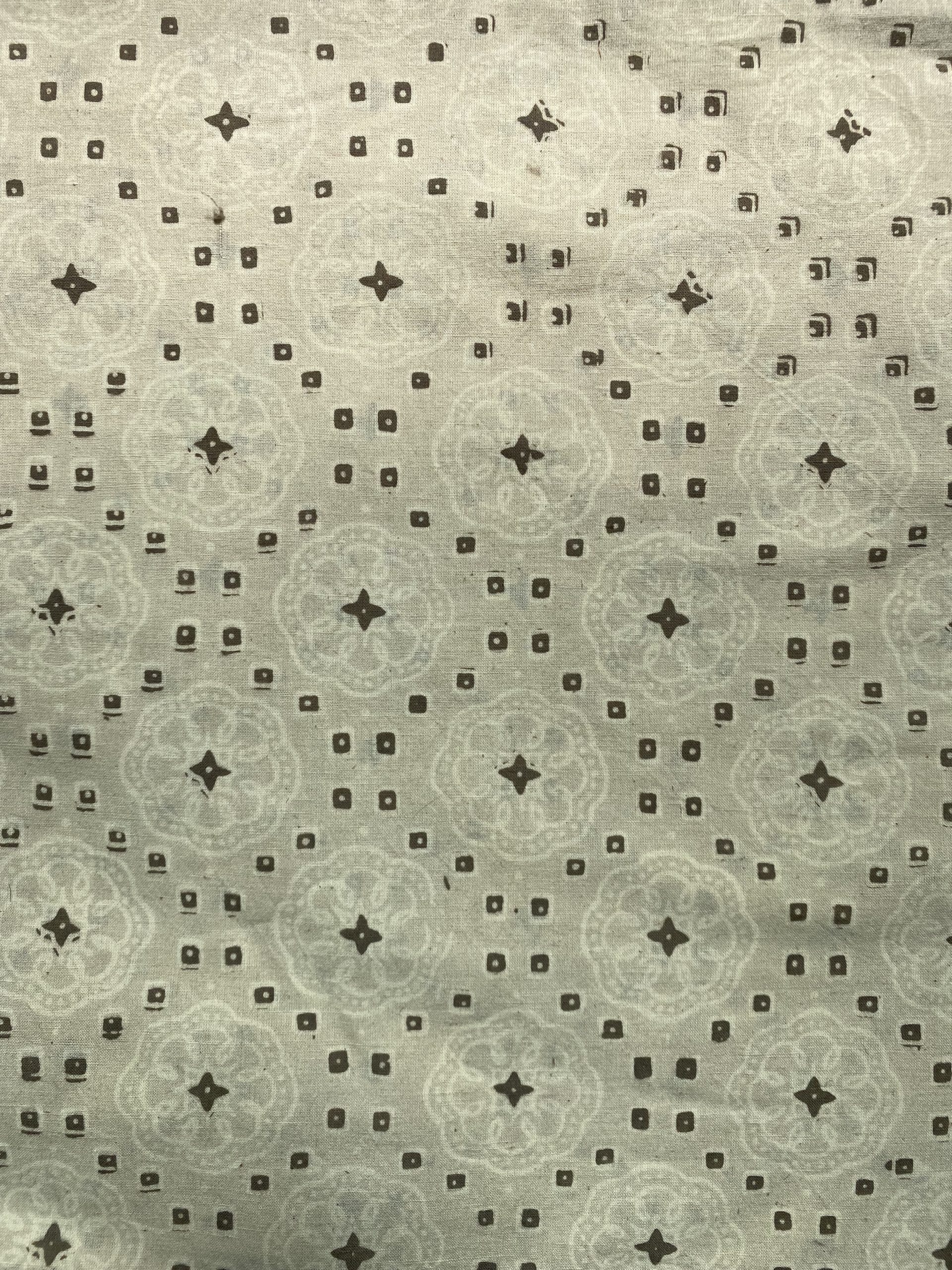Decorative fabric pattern with repeating small square and star motifs on a beige background