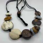 a handmade necklace made from ceramic flat circular beads