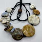 a handmade necklace made from ceramic flat circular beads